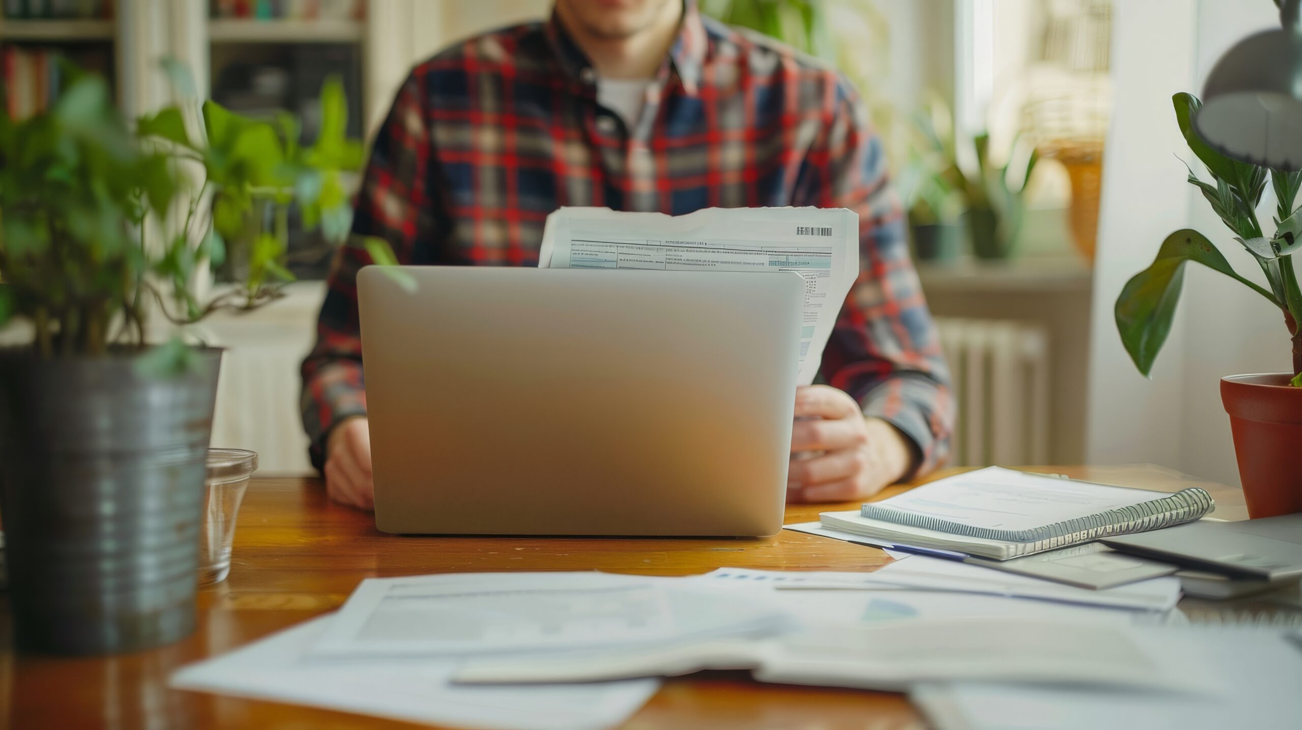 Vállalkozó papírok és laptop mellett számol: a kézi számolgatás az egyik jele, hogy kinőtted a táblázatot