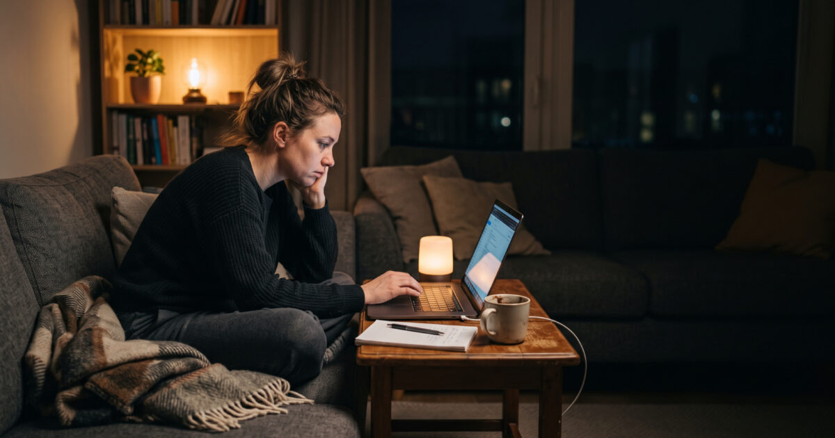 Érdeklődő este a nappaliban laptopon ajánlatot kér egy szakembertől, munkaidőn kívül